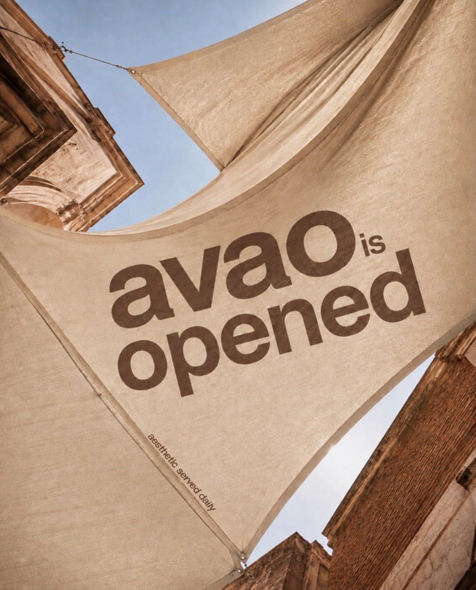 avao · Segelbanner „avao is opened“ zwischen Altbaufassaden
